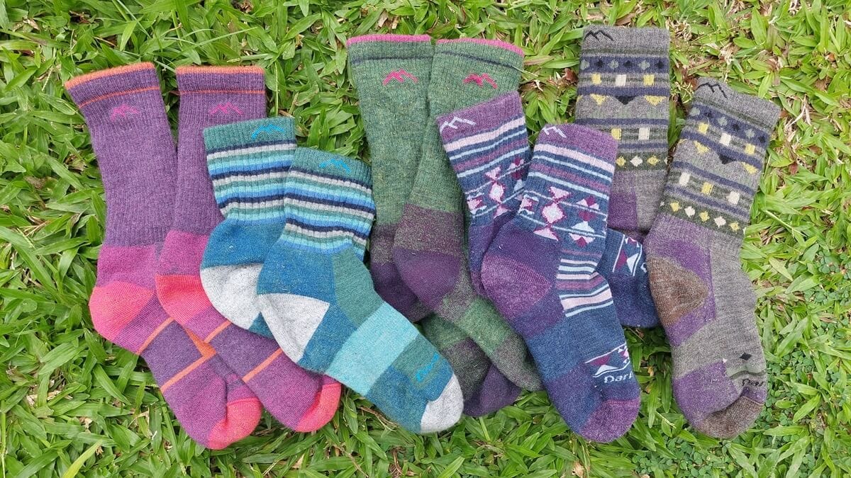 An array of Darn Tough Day hiking socks on a grass